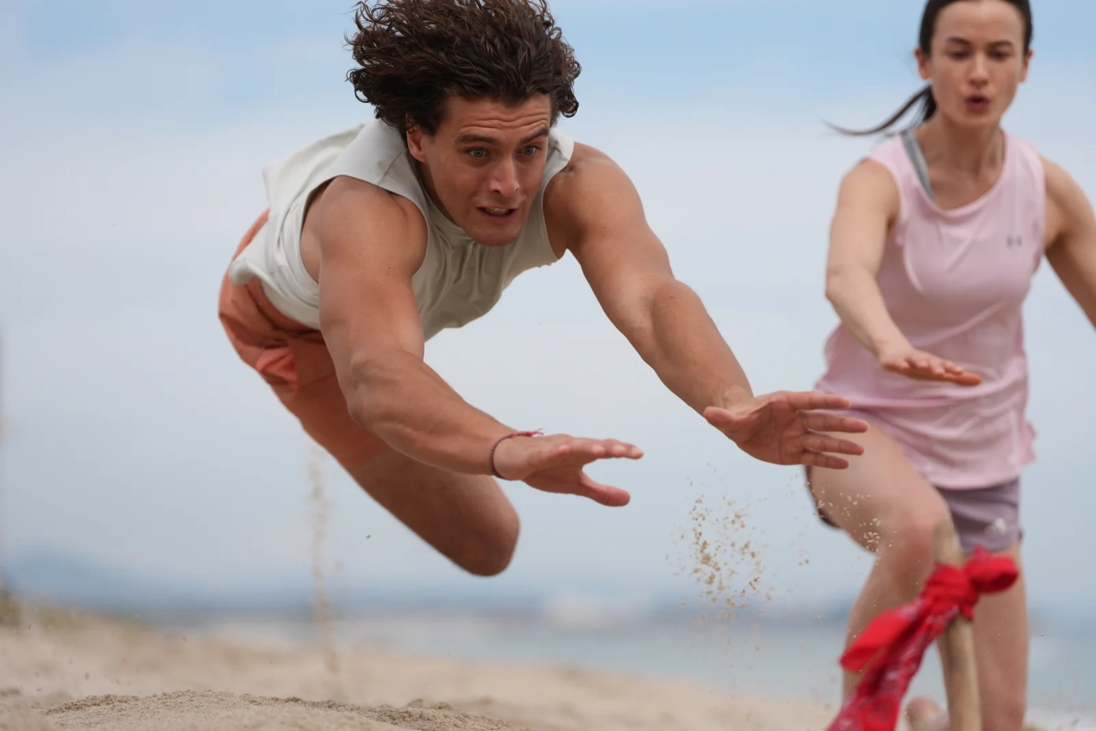 Mężczyzna skaczący po flagę na plaży — zatrzymany ruch