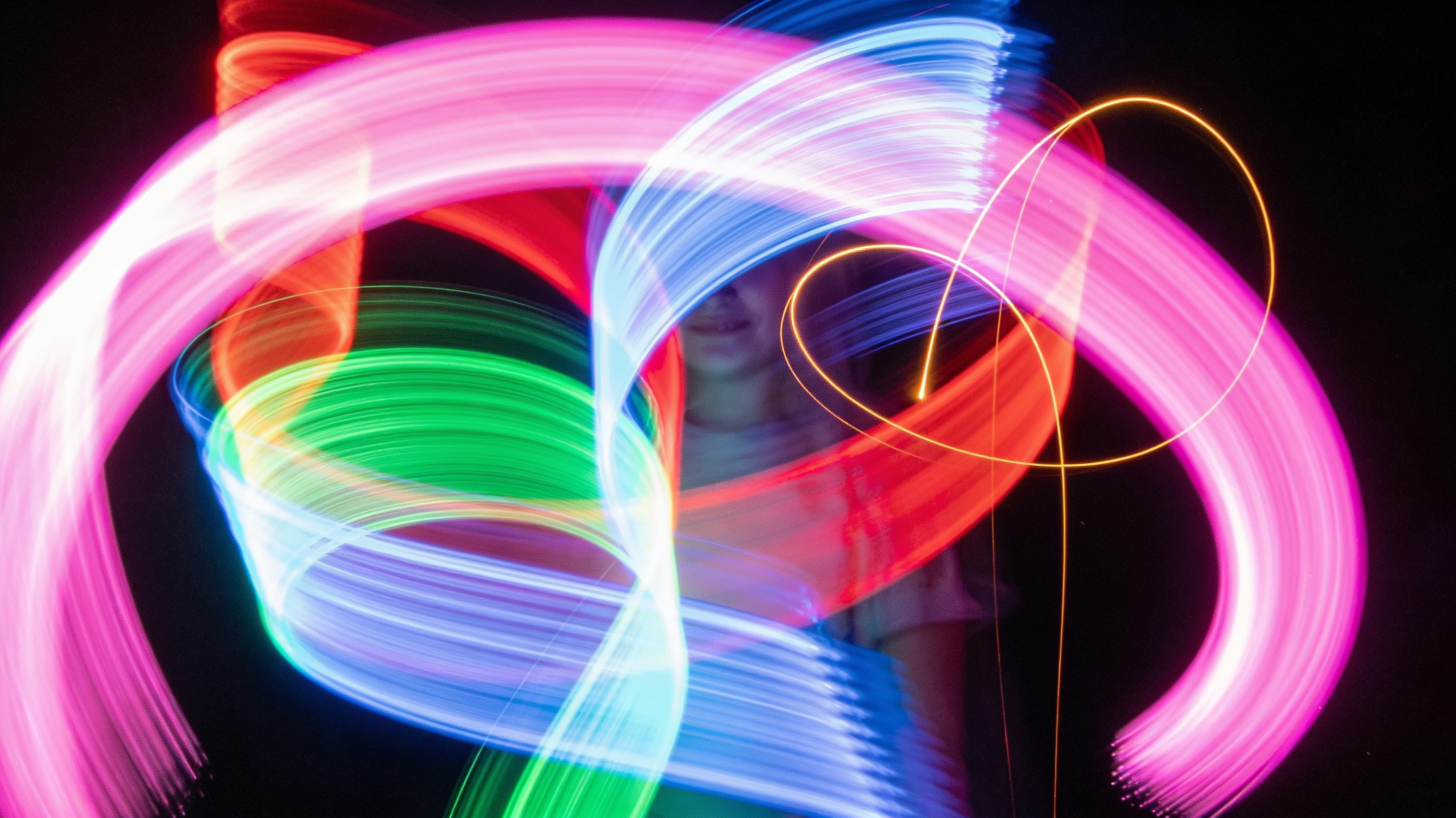 Luminografia — malowanie światłem w ciemności, kolorowe smugi świetlne tworzone długą ekspozycją